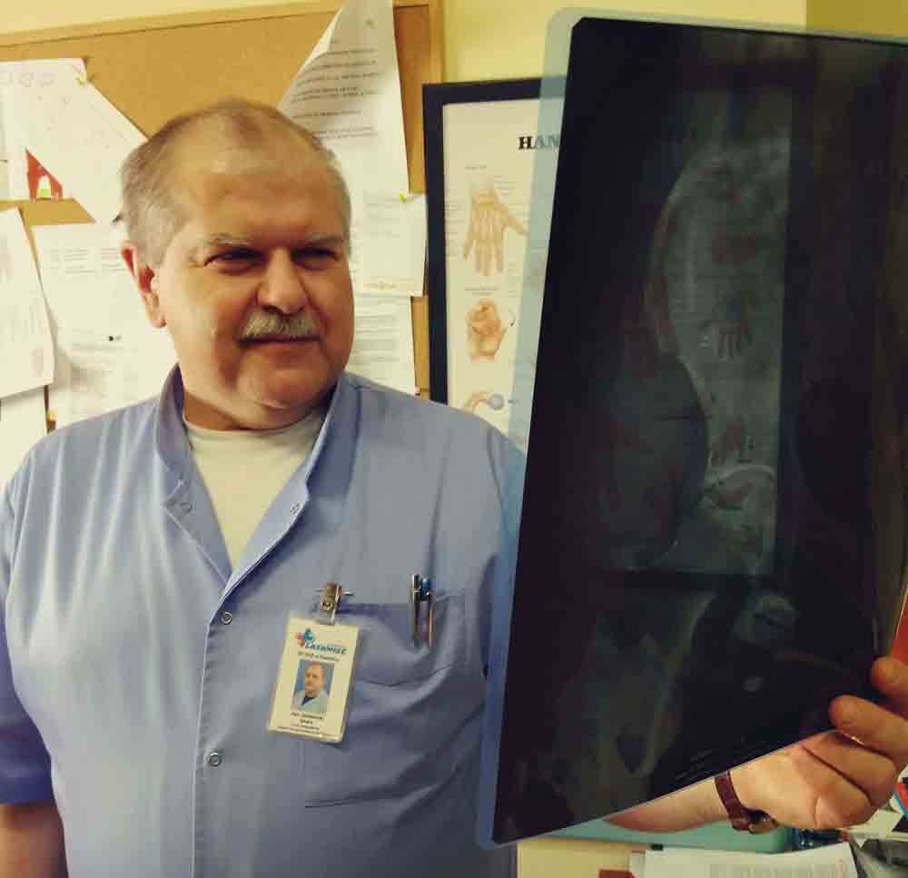 Lekarz ortopeda Jan Jazienicki w Świdnica trzyma zdjęcie roentgenowskie stawu biodrowego